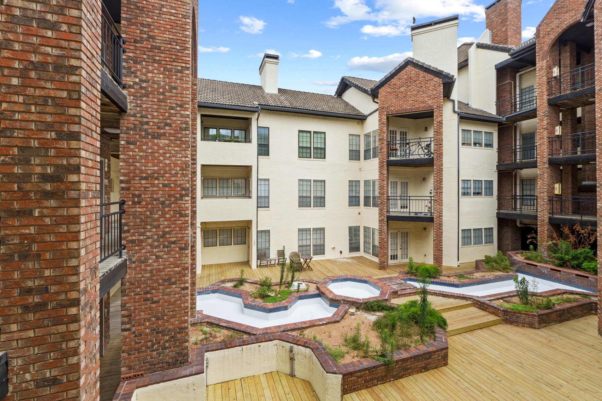 3001 Cedar Street, Unit A214 Austin, TX 78705 - Photo 2 of 23 a view of a patio with couches table and chairs with wooden floor and plants