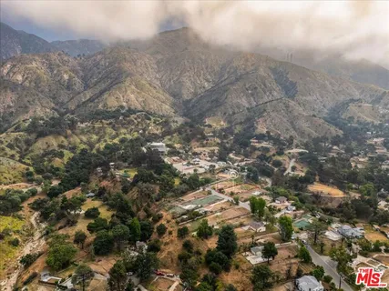 a view of dirt field with trees around