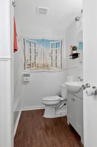 a bathroom with a toilet a sink and mirror