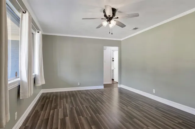 a view of an empty room with wooden floor