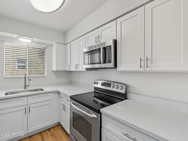 a kitchen with white cabinets appliances and sink