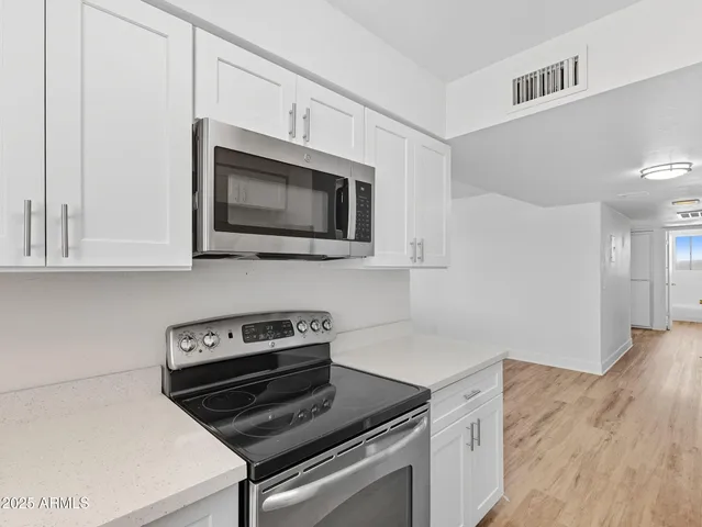 a kitchen with cabinets and steel appliances