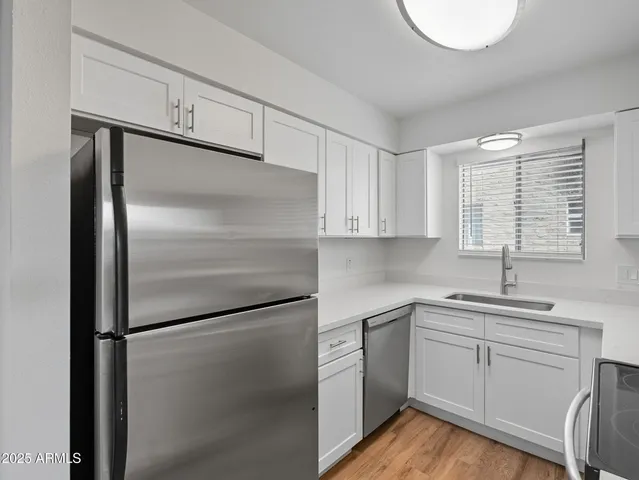 a kitchen with a refrigerator sink and cabinets