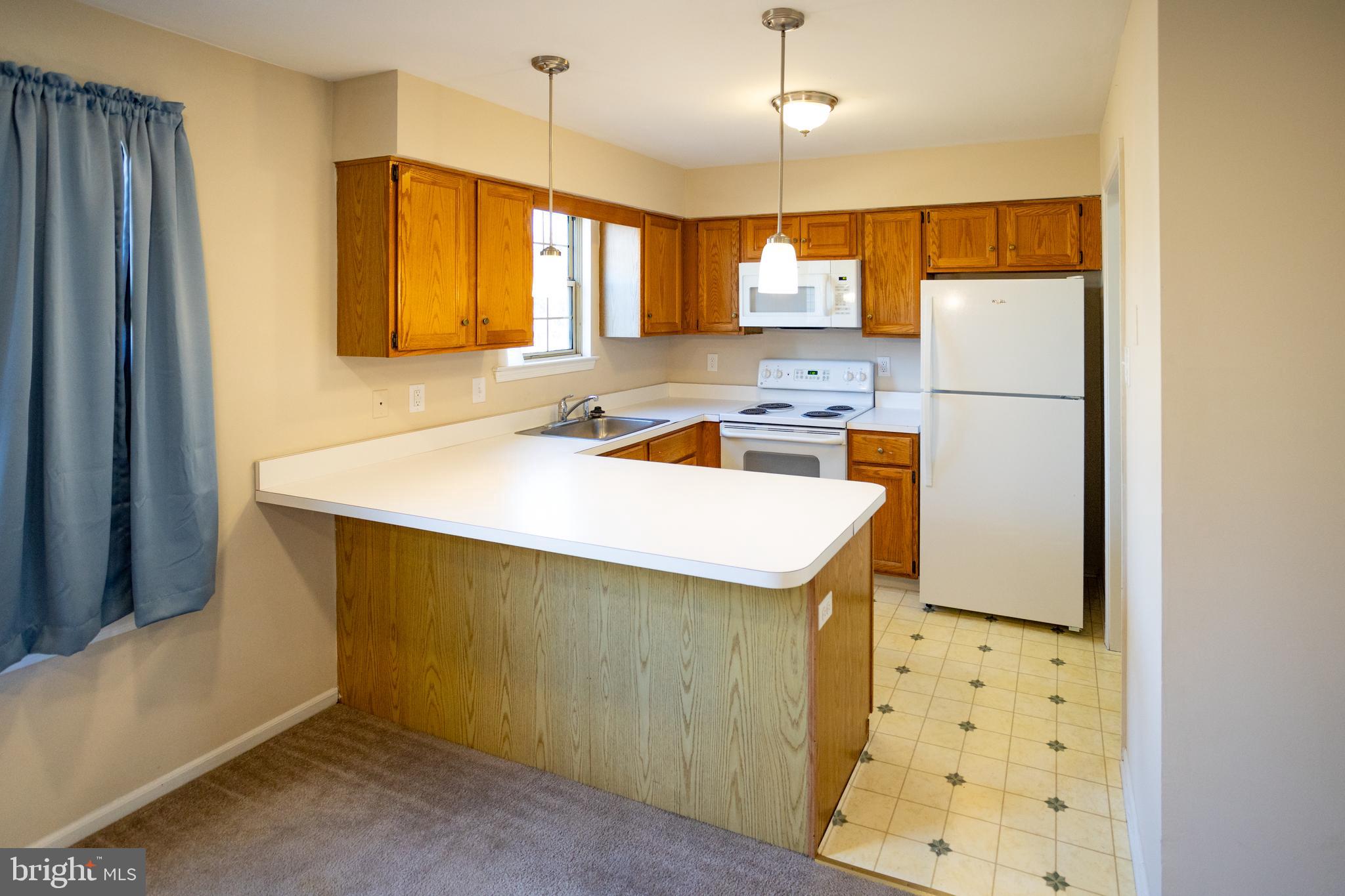 322 Kent Lane Perkasie, PA 18944 - Photo 11 of 36 a kitchen with a sink a stove a refrigerator and cabinetry
