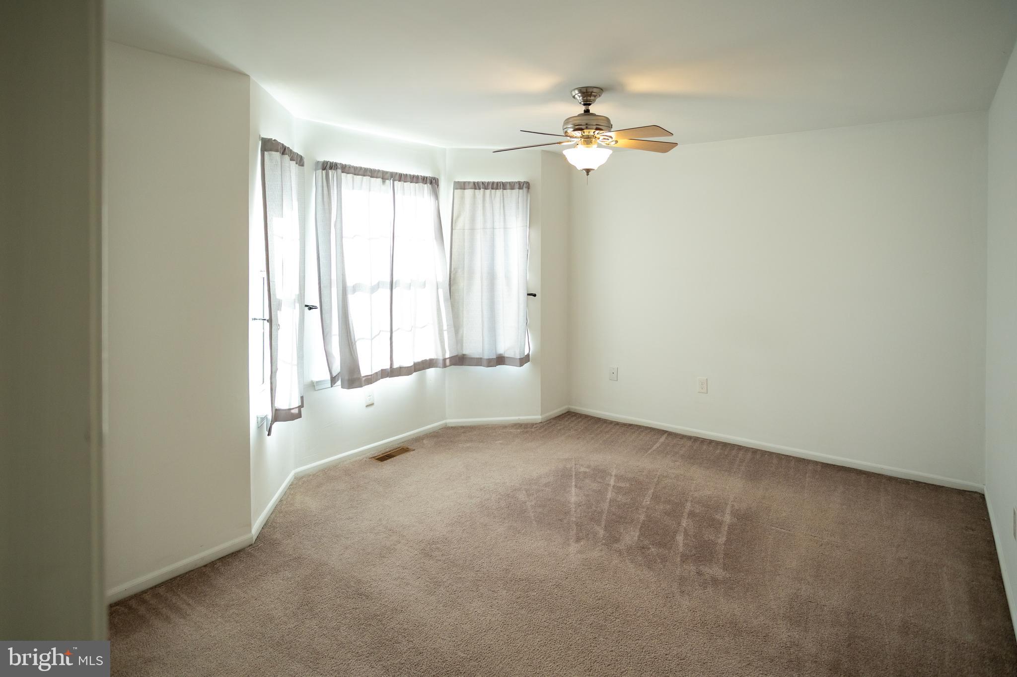 322 Kent Lane Perkasie, PA 18944 - Photo 17 of 36 an empty room with a chandelier fan and windows