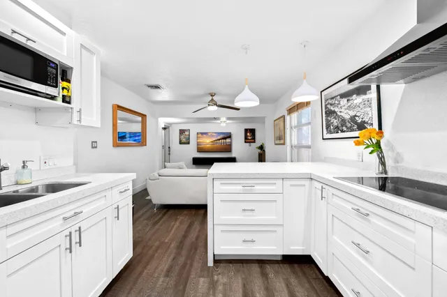 a kitchen with white cabinets and stainless steel appliances