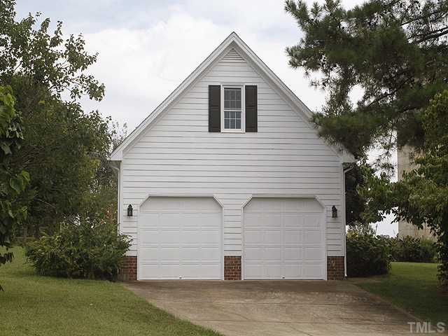 7221 Spring Meadow Lane Raleigh, NC 27606 - Photo 22 of 25 Additional two car garage that has been used as a workshop - insulated, workbench, cabinets, vacuum system, ceiling fan,windows and upstairs storage - great space for cars, boats, crafts, storage - terrific.