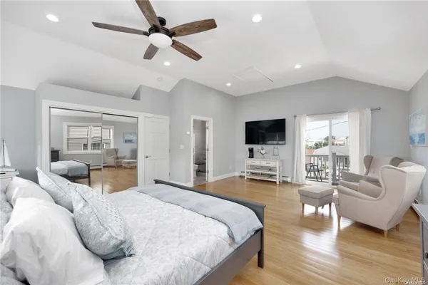 a spacious bedroom with a bed a flat screen tv and couches