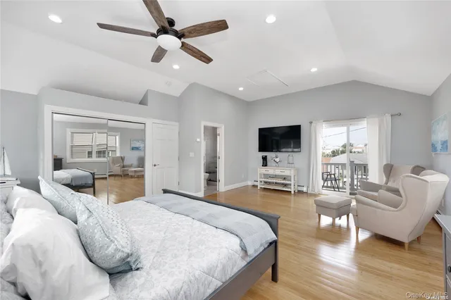 a spacious bedroom with a bed a flat screen tv and couches