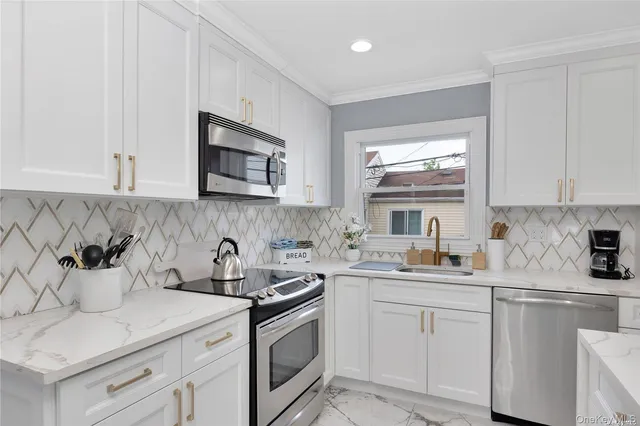 a kitchen with stainless steel appliances white cabinets sink and stove top oven