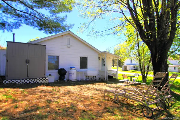 a view of a backyard with large trees and wooden fence
