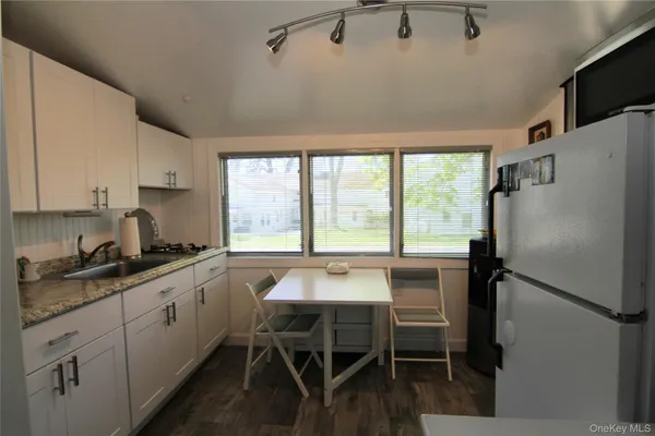 a kitchen with a table chairs refrigerator and cabinets