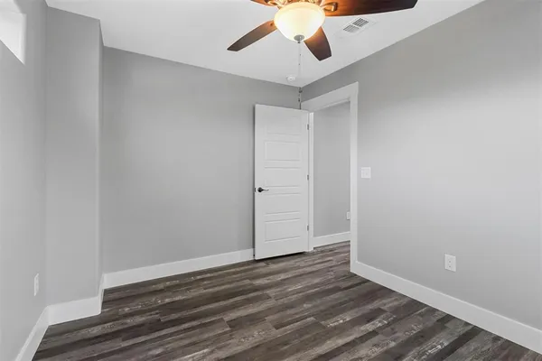 a view of room with wooden floor and ceiling fan