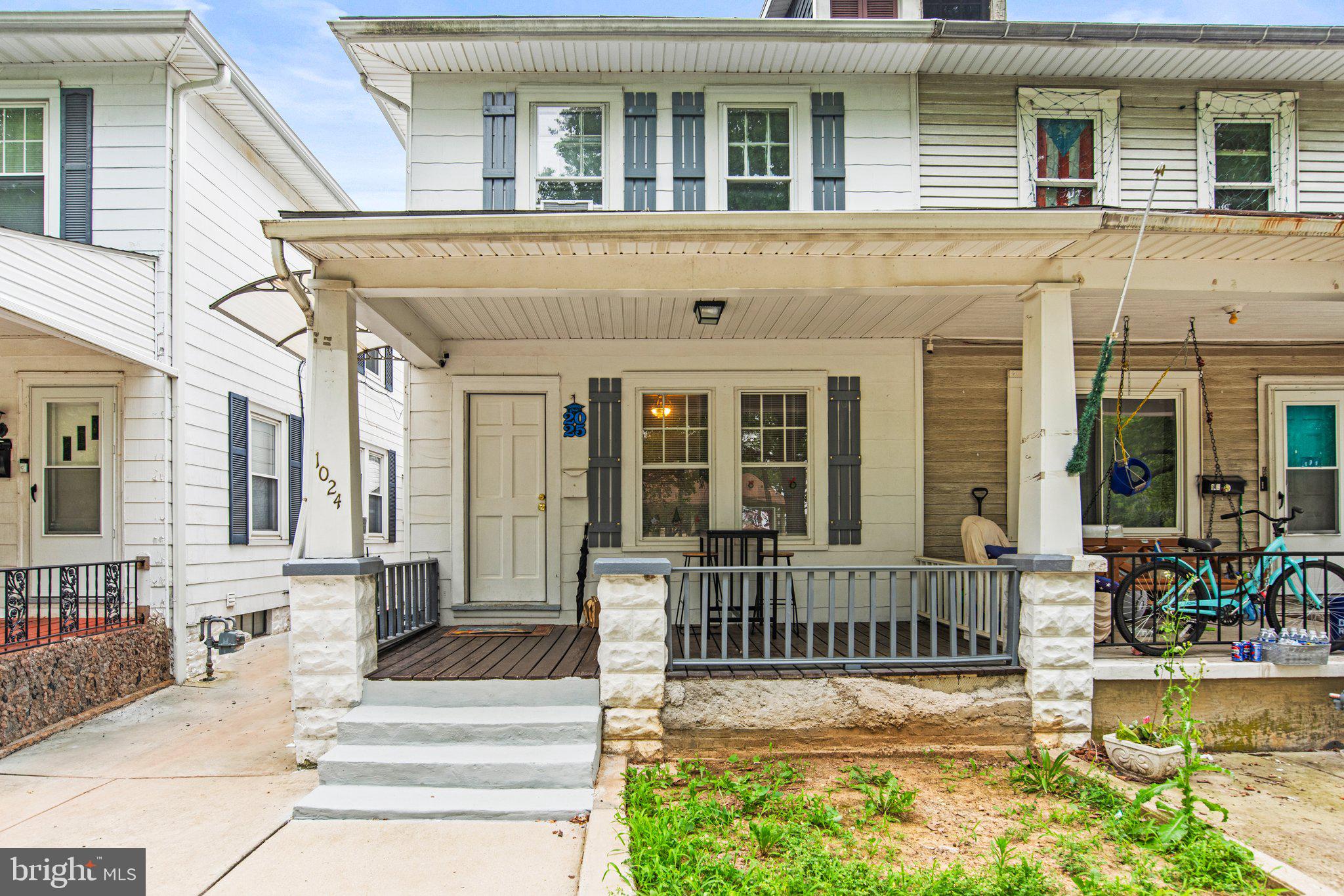 a view of a house with a small yard and wooden floor and fence