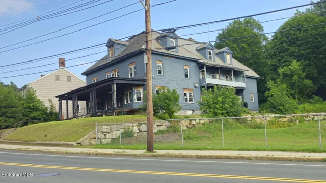 a view of a house with a small yard and potted plants