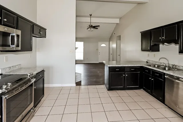 a kitchen with stainless steel appliances granite countertop a sink stove and cabinets