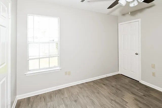 a view of wooden floor fire place and windows in a room