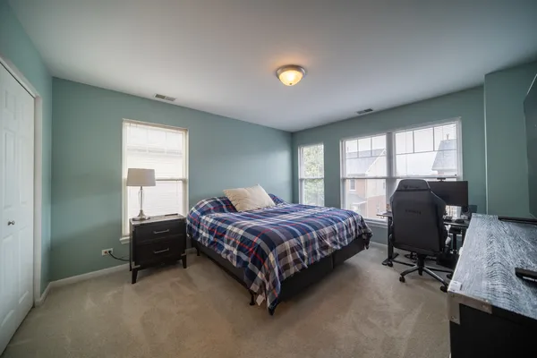 a bedroom with a bed chair and a window