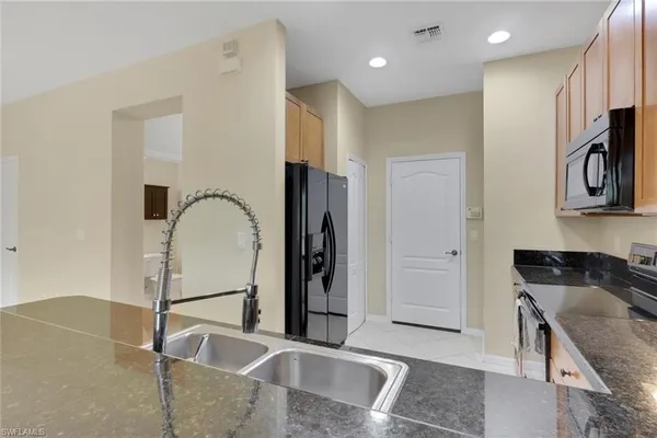 a kitchen with stainless steel appliances granite countertop a refrigerator and a sink