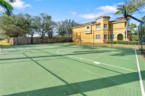 a view of a white house with a tennis court