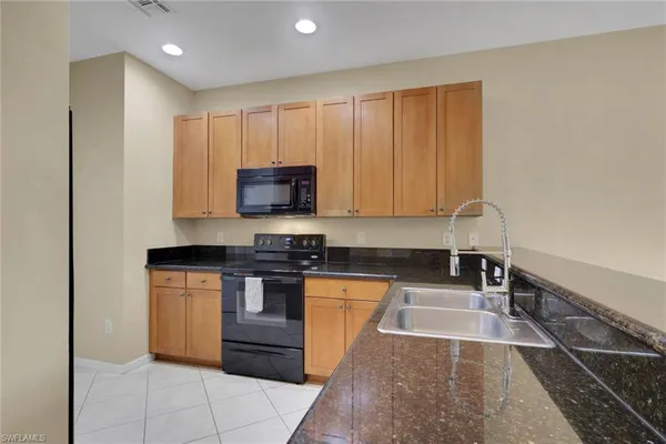 a kitchen with stainless steel appliances granite countertop a stove a sink and a microwave