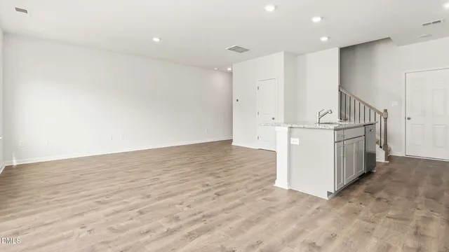 a view of a bedroom with wooden floor and a window