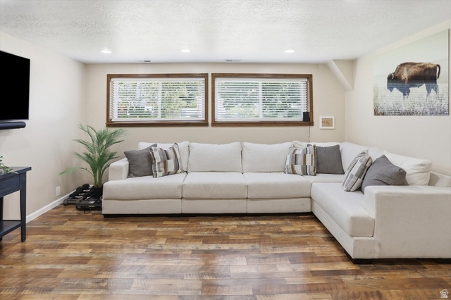 8938 Manchester Lane Sandy, UT 84093 - Photo 27 of 50 Spacious living area featuring wood-finish flooring, two windows with blinds, recessed ceiling lights, and light-toned wall paint
