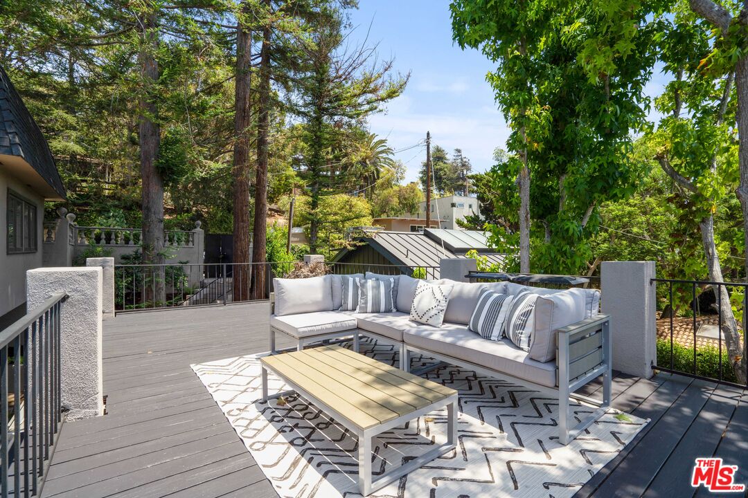 373 Mesa Road Santa Monica, CA 90402 - Photo 23 of 25 a view of a patio with couches and a dining table and chairs with wooden floor and fence