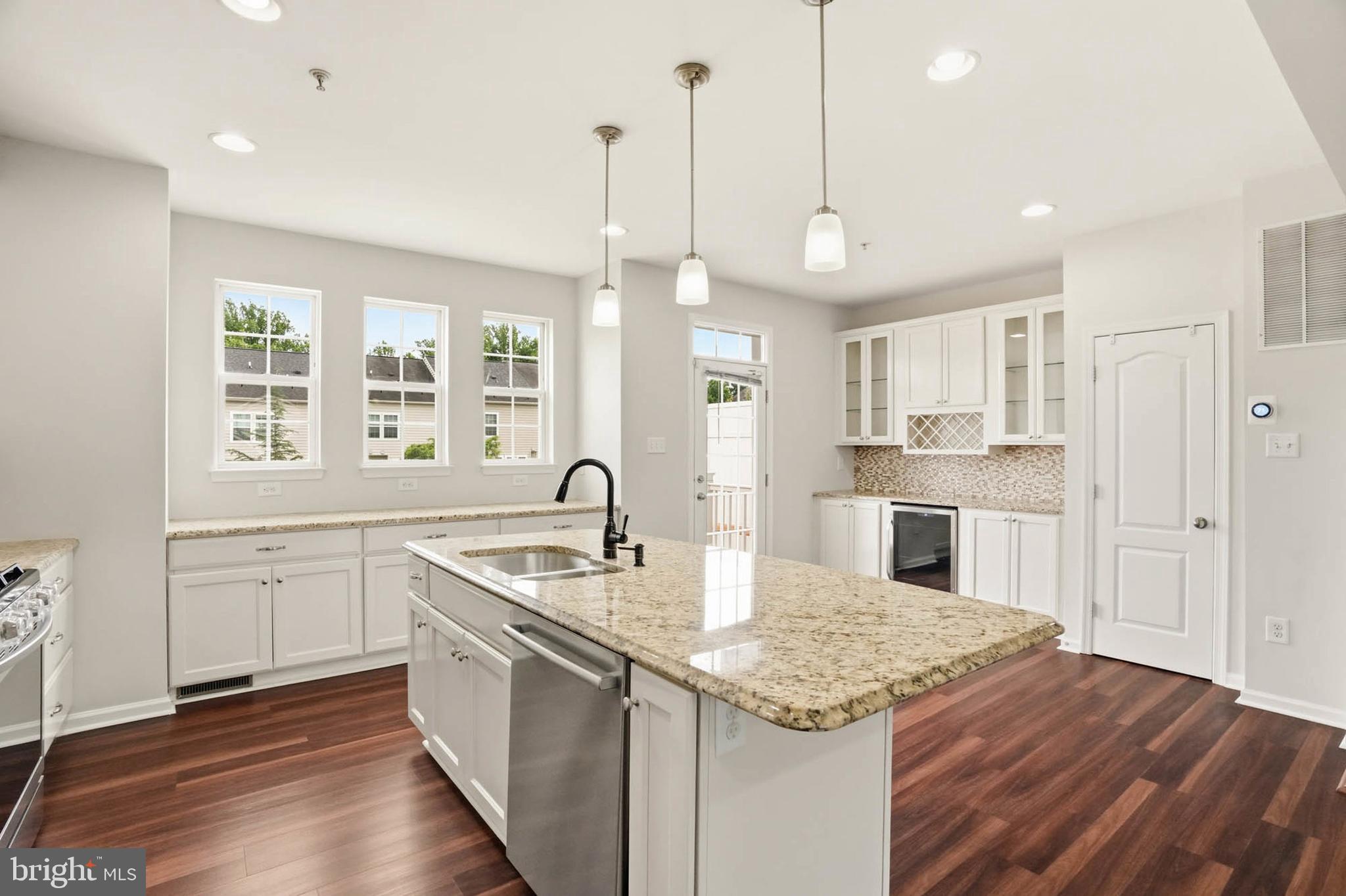 9817 Solar Course Laurel, MD 20723 - Photo 8 of 59 a kitchen with granite countertop kitchen island a sink appliances and a counter space