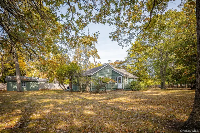 a front view of a house with a yard and trees