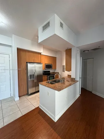 a view of kitchen with refrigerator stove microwave and cabinets