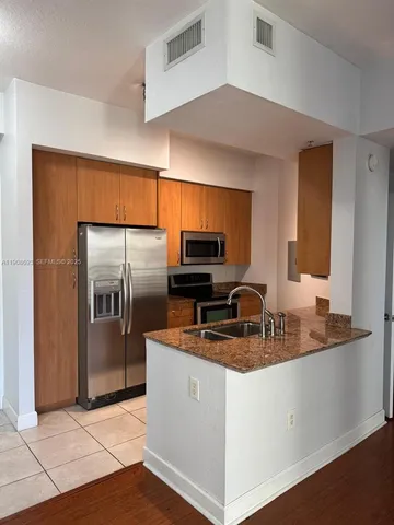 a kitchen with stainless steel appliances granite countertop a sink refrigerator and microwave