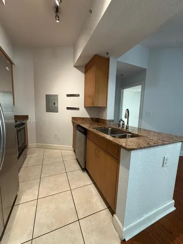 a kitchen with granite countertop a sink and a stove top oven