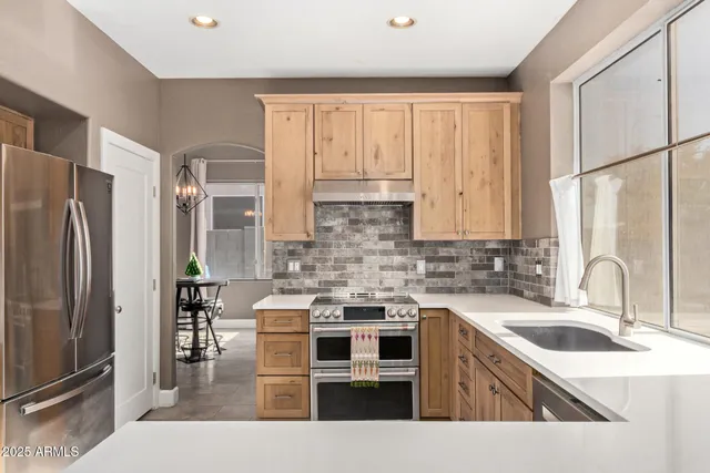 a kitchen with stainless steel appliances a sink stove and refrigerator
