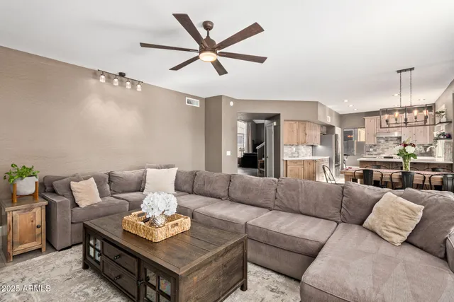 a living room with furniture and a view of kitchen