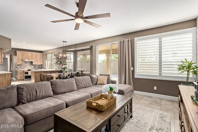 a living room with furniture and a large window with kitchen view