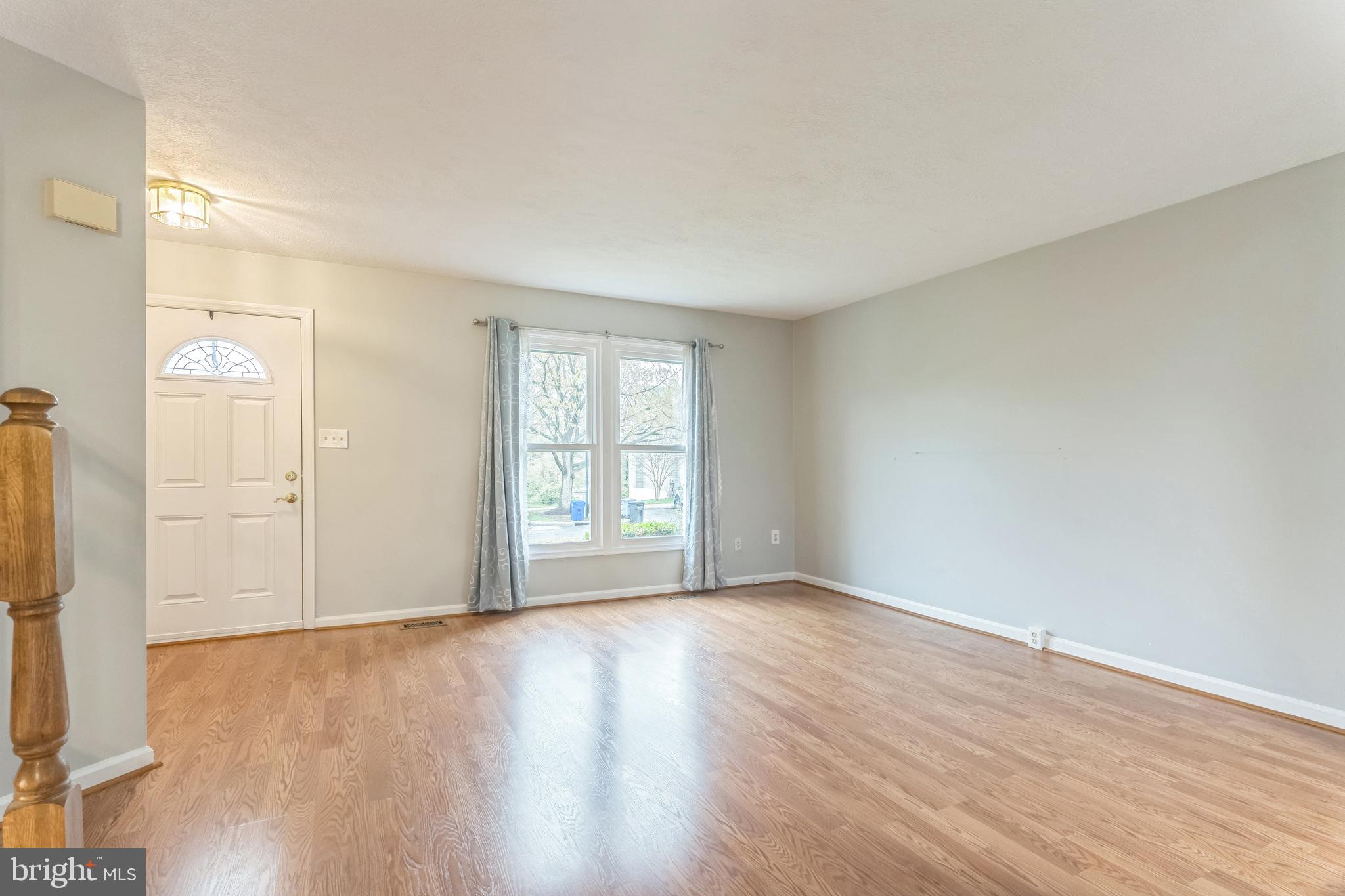 5620 Denton Court Frederick, MD 21703 - Photo 5 of 33 an empty room with wooden floor and a window