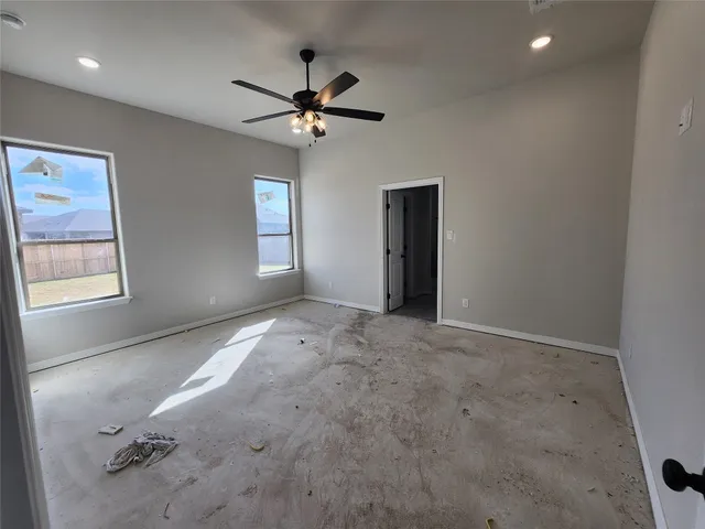 a view of empty room with window and ceiling fan