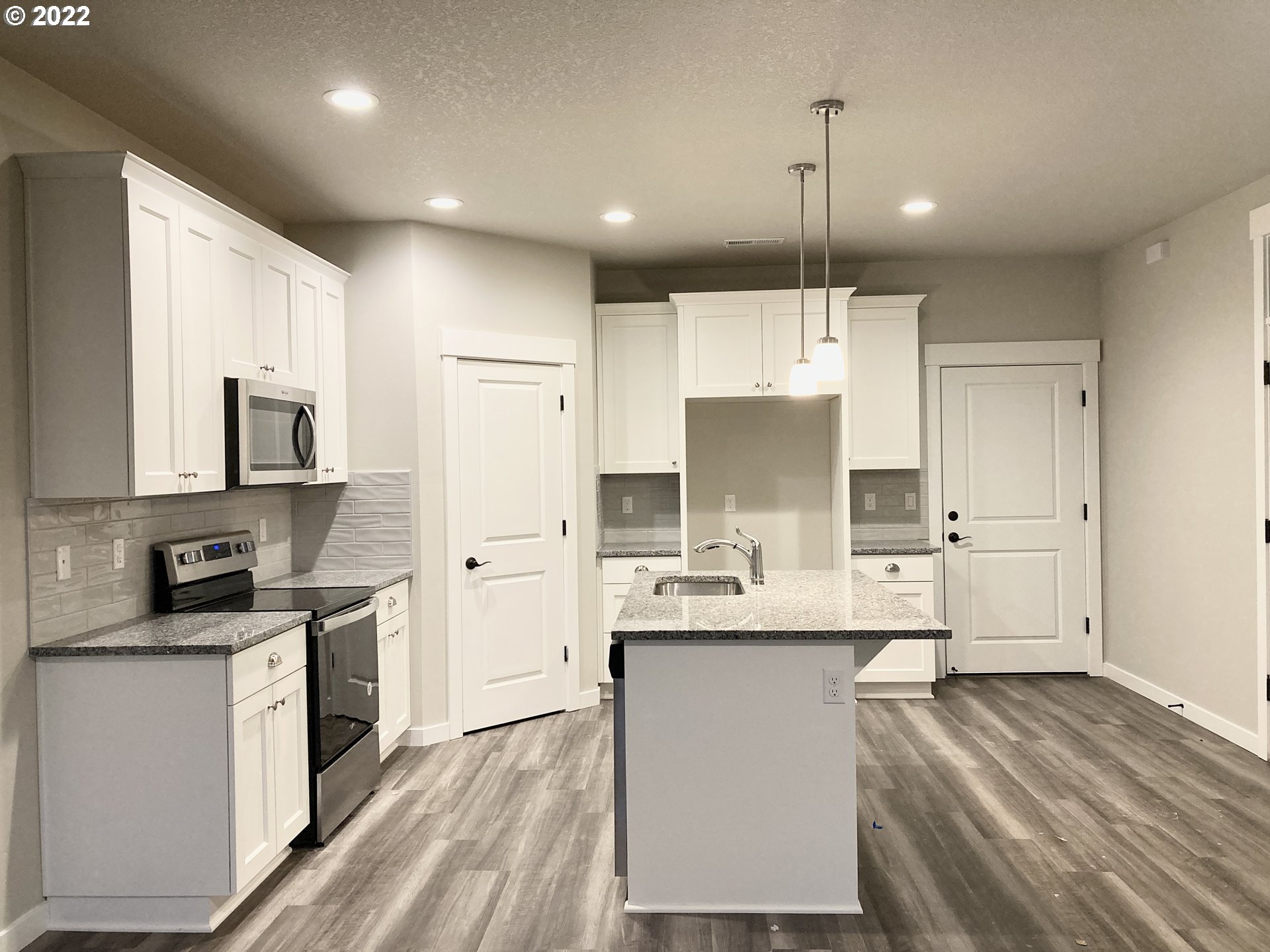 7315 South 13th Street Ridgefield, WA 98642 - Photo 4 of 11 a kitchen with kitchen island granite countertop a sink cabinets and stainless steel appliances