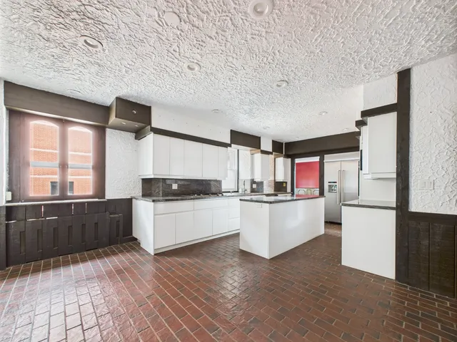 a kitchen with a refrigerator and wooden cabinets