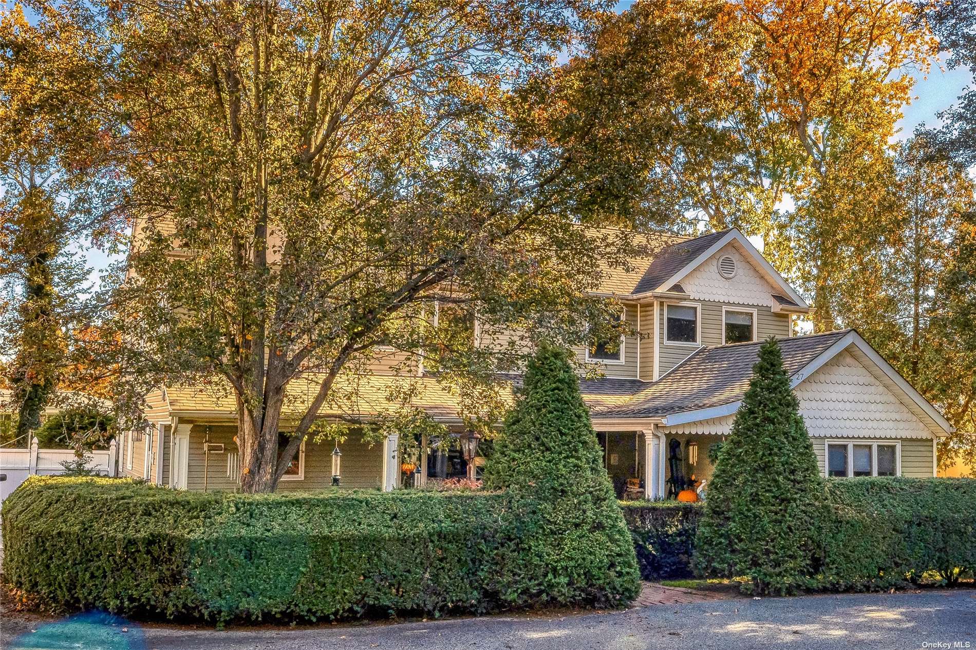 a front view of a house with a yard and trees