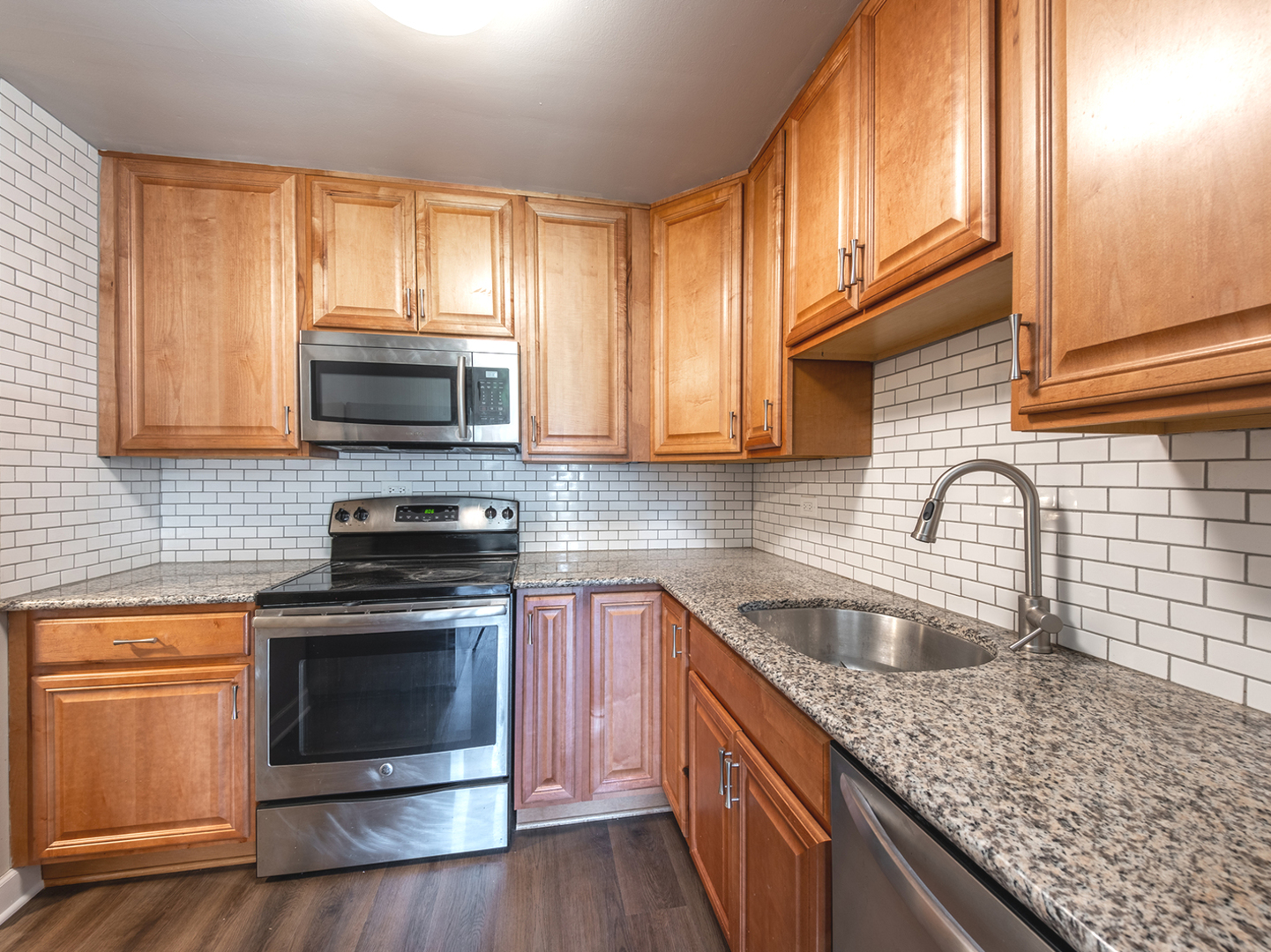 425 Walnut Creek Road, Unit 1207 Lisle, IL 60532 - Photo 3 of 11 a kitchen with sink a microwave a stove and cabinets
