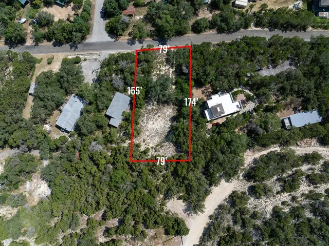 an aerial view of a house with a yard and trees all around