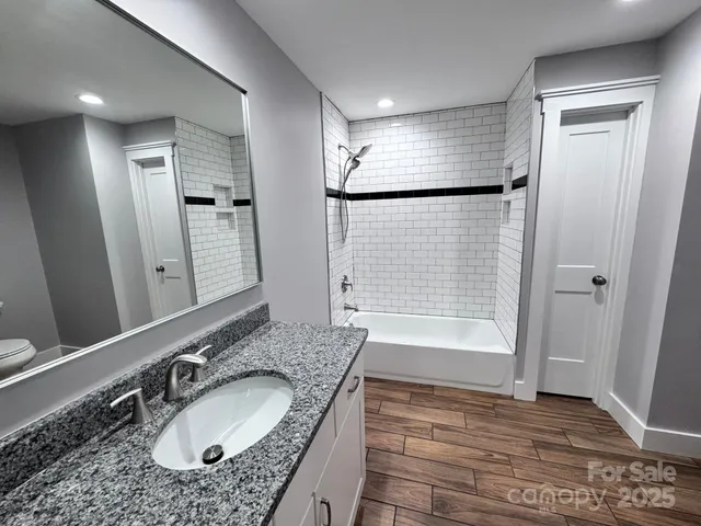an empty room with wooden floor chandelier fan and windows
