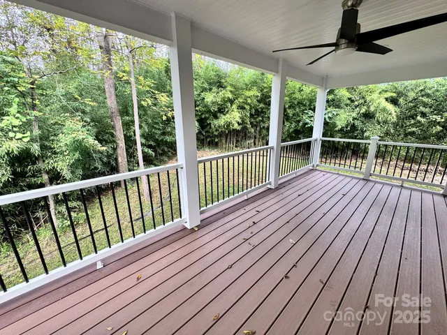 a view of a house with a yard plants and large tree