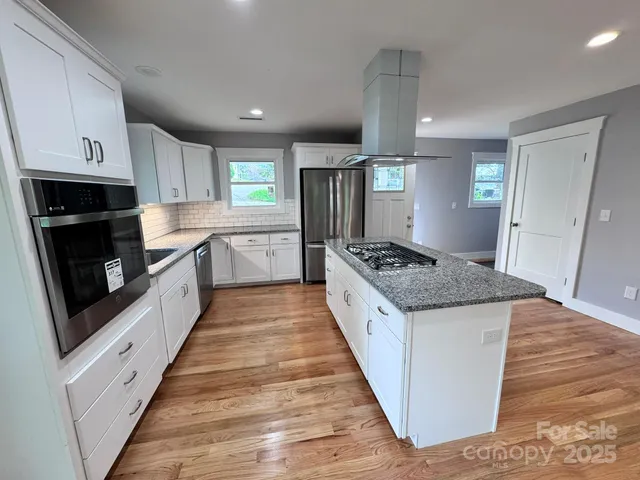 a kitchen with granite countertop white cabinets and a sink