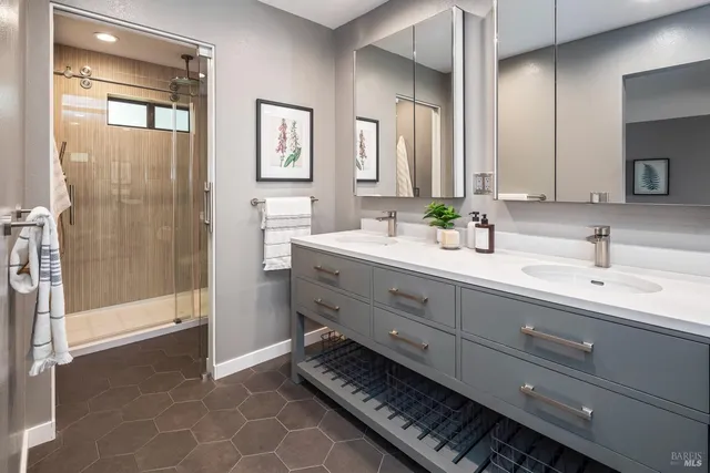 a spacious bathroom with double vanity and a mirror