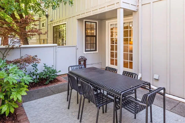 a view of a patio with table and chairs and potted plants