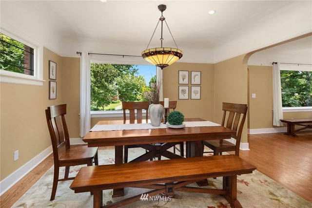 a dining room with furniture a chandelier and wooden floor