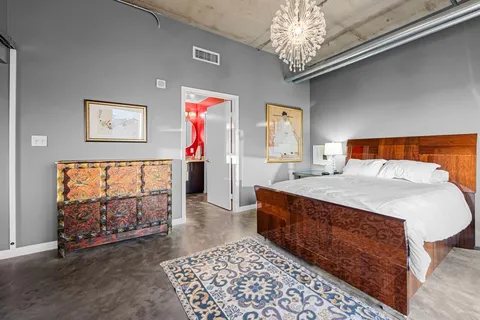 a bedroom with a large bed and a chandelier